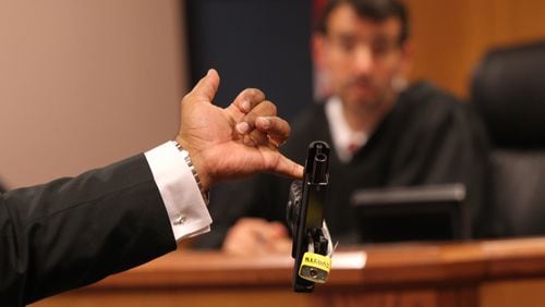April 21, 2017, Atlanta, Georgia - Fulton assistant district attorney Clint Ruckers presents the handgun found at the home of Tex McIver to Judge Robert McBurney at a court appearance for prominent Atlanta attorney Tex McIver in Atlanta, Georgia. McIver may have his bond revoked after authorities conducting a search found a gun stored in a drawer full of socks at his home. (HENRY TAYLOR / HENRY.TAYLOR@AJC.COM)