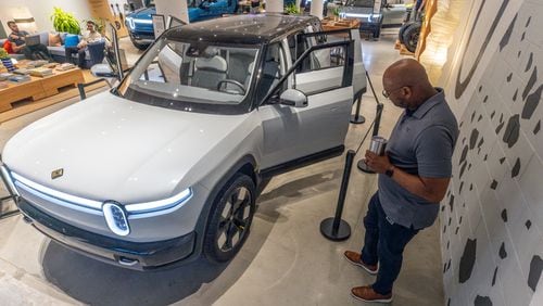Rivian employee Russ Mooney looks over the new R2 prototype, which the company says will eventually be made in Georgia, at the Ponce City Market in Atlanta on April 27, 2024. (Steve Schaefer / AJC)