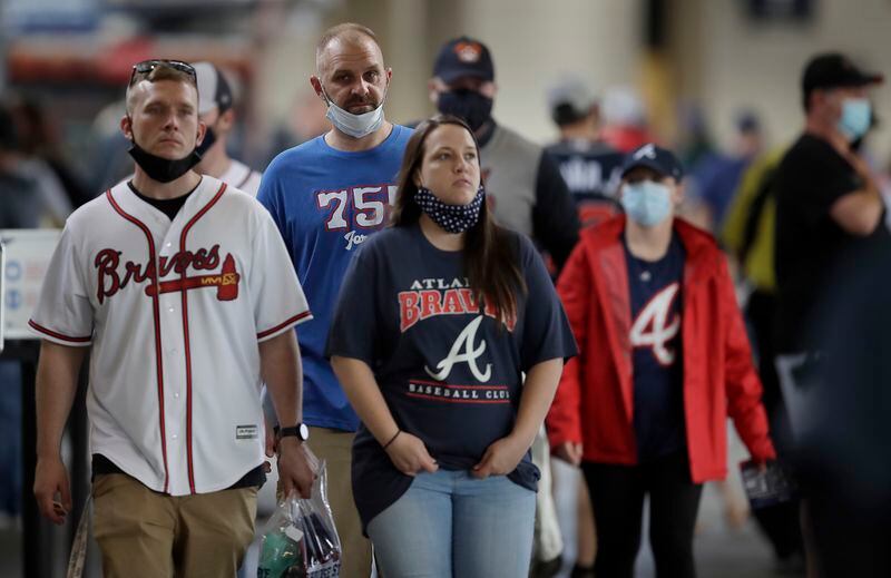 Fans leave Truist Park upon learning a baseball game between the Atlanta Braves and the Arizona Diamondbacks had been postponed on Saturday, April 24, 2021, in Atlanta. The Diamondbacks and Braves will play in a traditional doubleheader Sunday. (AP Photo/Ben Margot)