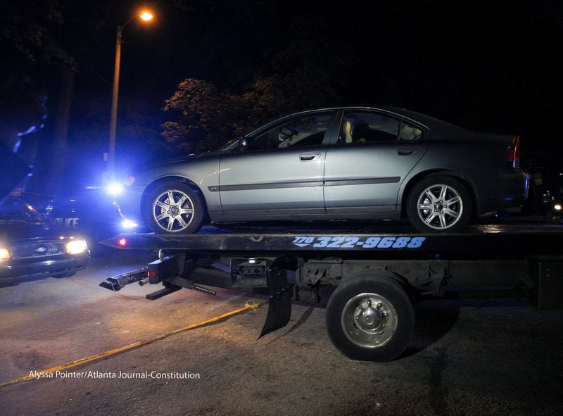 Police remove a shooting victim's car from a condominium complex off Snapfinger Woods Drive in DeKalb County on Friday morning. ALYSSA POINTER / ALYSSA.POINTER@AJC.COM