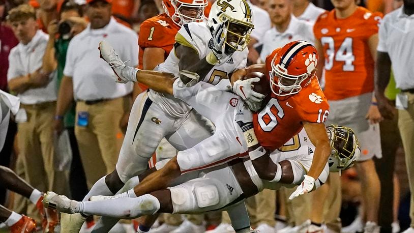 Clemson wide receiver E.J. Williams is brought down by Georgia Tech's Ayinde Eley (10) and Tariq Carpenter after a catch in the second half of a college football game in September 2021. For the second consecutive year, the preseason media poll conducted by the ACC projects the Yellow Jackets to finish sixth in the Coastal Division. (AP Photo/John Bazemore)