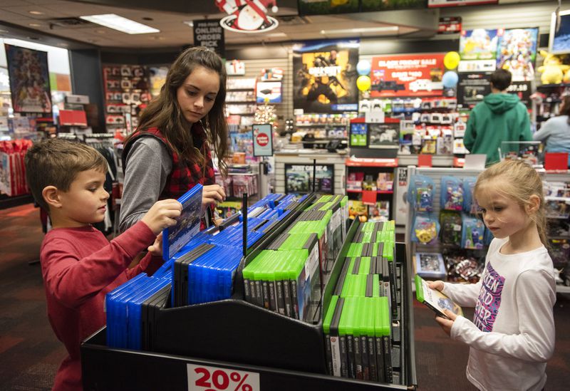 Leslie Hatch of Rusk shops with Rylan Hatch, 7, and Bailey Hatch, 6, at GameStop at Broadway Square Mall in Tyler, Texas ahead of Black Friday on Tuesday Nov. 20, 2018. (Sarah A. Miller/Tyler Morning Telegraph via AP)