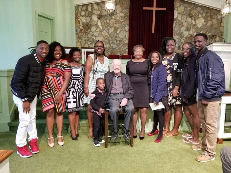 Eddrica Buckner, (blue jacket with the red shoes) and her family with President Carter during one of his Sunday School classes in 2018. 