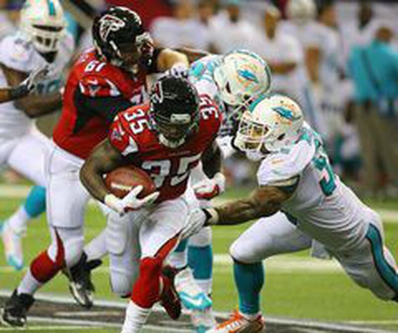 Falcons running back Antone Smith gets past Miami Dolphins linebacker Koa Misi for yardage during the first quarter of their NFL exhibition game on Friday, August 8, 2014, in Atlanta. (Photo by Curtis Compton/Ccompton@ajc.com)