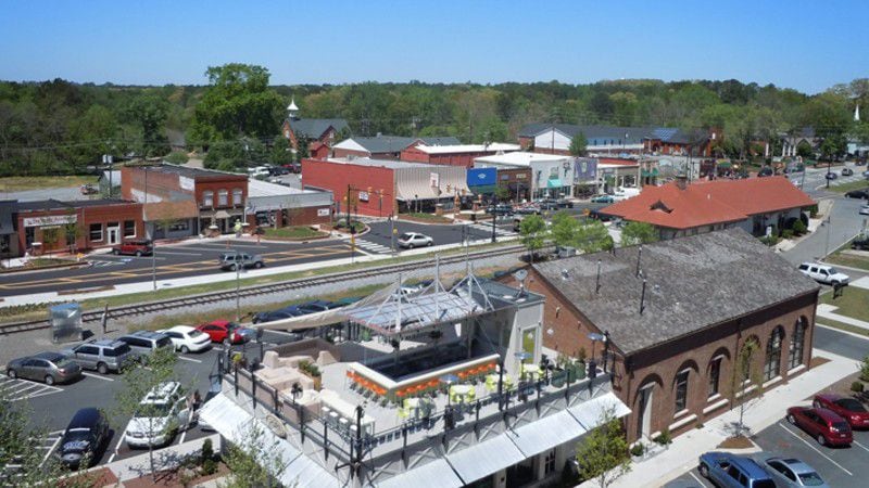 Downtown Woodstock with shops, restaurants and residences on either side of Main Street and the historic train depot in the center . AJC FILE