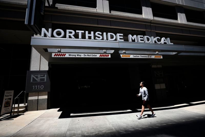 A person walks in front of the Northside Hospital Midtown medical building entrance in Midtown Atlanta on Thursday, May 4, 2023, the day after a gunman killed one woman and injured four more. (Miguel Martinez / miguel.martinezjimenez@ajc.com)
