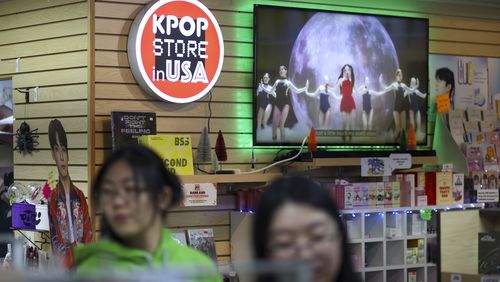 K-pop videos play on a monitor next to the store’s logo at the KPOP Store in USA, Thursday, November 9, 2023, in Doraville, Ga. K-Pop is growing in popularity in Atlanta and the KPOP Store in USA is one of the larger stores in Atlanta. (Jason Getz / Jason.Getz@ajc.com)