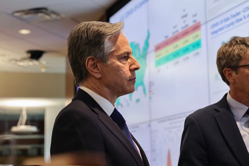 U.S. Secretary of State Antony Blinken tours the Center for Disease Control in Atlanta on Friday, May 5, 2023. Behind Blinken is the CDC's emergency operations center's screen showing a map of COVID-19 spread. It is mostly green, meaning few outbreaks. (Natrice Miller/Natrice.miller@ajc.com) 