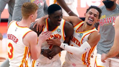 Atlanta Hawks' Tony Snell (center) is congratulated by Kevin Huerter (3) and Trae Young after his basket at the buzzer that gave the team a 121-120 win over the Toronto Raptors Thursday, March 11, 2021, in Tampa, Fla. (Mike Carlson/AP)