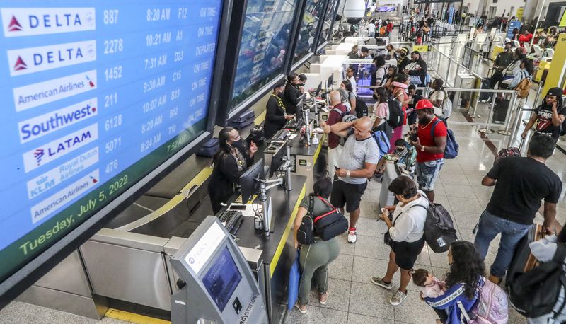 July 5, 2022 Hartsfield-Jackson International Airport: Airline travelers lined up at the ticket counter on the North Terminal at Hartsfield-Jackson International Airport on Tuesday, July 5, 2022. (John Spink / John.Spink@ajc.com)