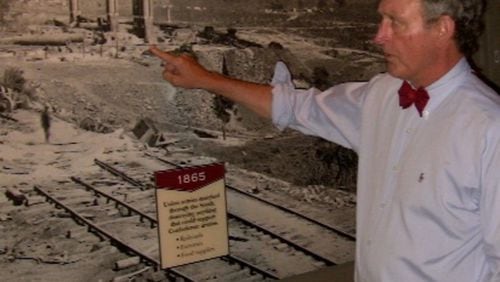 Steve Davis, a local historian and author, stands in front of photo of the wrecked train that held the Confederate army’s ammunition reserve, blown up on the night of Sept. 1-2, 1864, as the Rebel army evacuated Atlanta. Davis has briefed Jimmy Carter and Carter’s family on historical events that occurred where the Carter Center now stands.