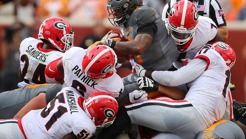Georgia defenders David Marshall (51),  Natrez Patrick (6), Dominick Sanders (24), Lorenzo Carter (7) and Davin Bellamy (17) gang tackle Tennessee running back John Kelly at the line of scrimmage for no gain during the first half of an NCAA college football game against Tennessee on Saturday, Sept. 30, 2017, in Knoxville, Tenn. (Curtis Compton/ccompton@ajc.com)