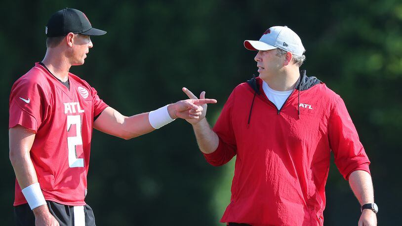 Falcons quarterback Matt Ryan and head coach Arthur Smith confer during the fourth day of training camp practice Sunday, Aug. 1, 2021, in Flowery Branch. (Curtis Compton / Curtis.Compton@ajc.com)