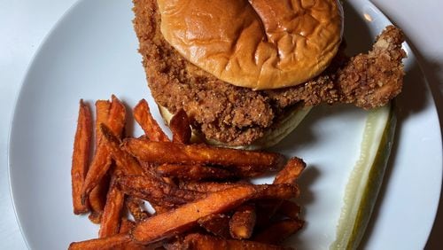 Iron Hill offers a fried chicken sandwich with bread and butter pickles and sriracha ranch dressing on a potato bun, plus sweet potato fries. Bob Townsend for The Atlanta Journal-Constitution