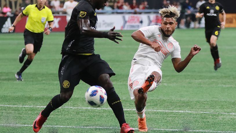 Atlanta United forward Josef Martinez makes the MLS season record tieing goal past Columbus Crew defender Jonathan Mensah for a 1-0 lead during the first half in a MLB soccer match on Sunday, August 19, 2018, in Atlanta.  Curtis Compton/ccompton@ajc.com