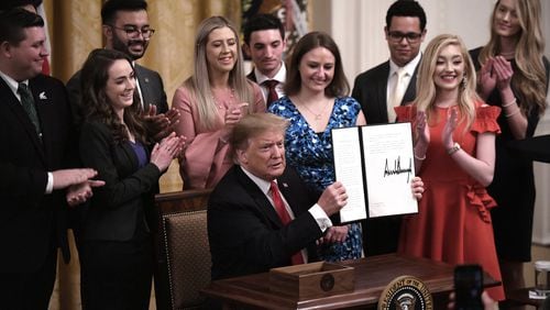 President Donald Trump holds a signed executive order to require colleges and universities to “support free speech” on campus or risk loss of federal research funds, during an event in the East Room of the White House on Thursday, March 21, 2019. (Olivier Douliery/Abaca Press/TNS)