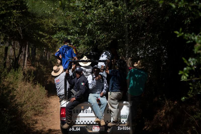 Locals ride in a National Guard truck in search of unlicensed water intakes and irrigation holding ponds that irrigate avocado and berry orchards during a drought in the mountains of Villa Madero, Mexico, Wednesday, April 17, 2024. Subsistence farmers and activists from the Michoacan town of Villa Madero organized teams to go into the mountains and rip out illegal water pumps and breach unlicensed irrigation holding ponds. (AP Photo/Armando Solis)