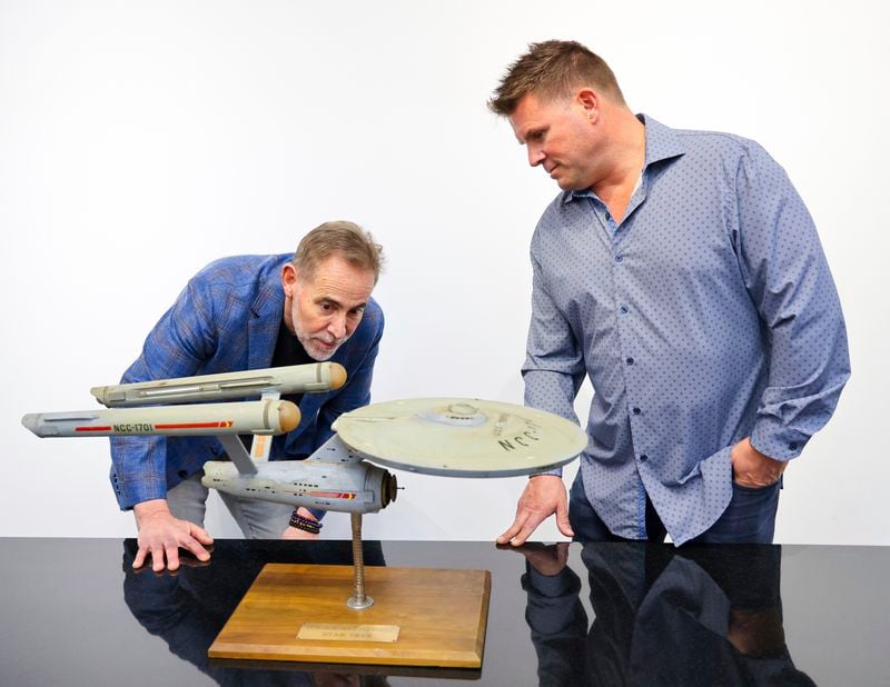 Joe Maddalena, executive vice president of Heritage Auctions, left, and Eugene “Rod” Roddenberry, the son of “Star Trek” creator Gene Roddenberry, view the recently recovered first model of the USS Enterprise at Heritage Auctions in Los Angeles, April 13, 2024. The model — used in the original “Star Trek” television series — has been returned to Eugene, decades after it went missing in the 1970s. (Josh David Jordan/Heritage Auctions via AP)