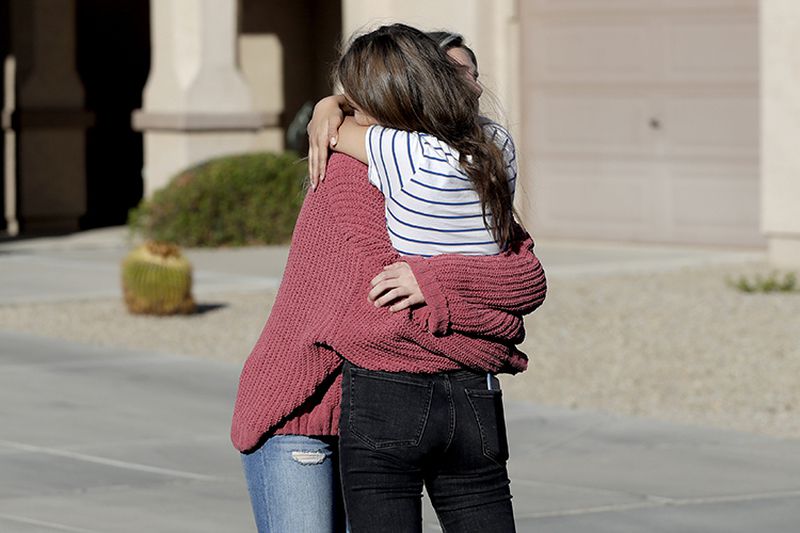 Madelyn Staddon, right, a relative of some of the members of a Mormon community who were attacked while traveling near the U.S.-Mexico border, embraces a neighbor outside her home Tuesday in Queen Creek, Ariz. 