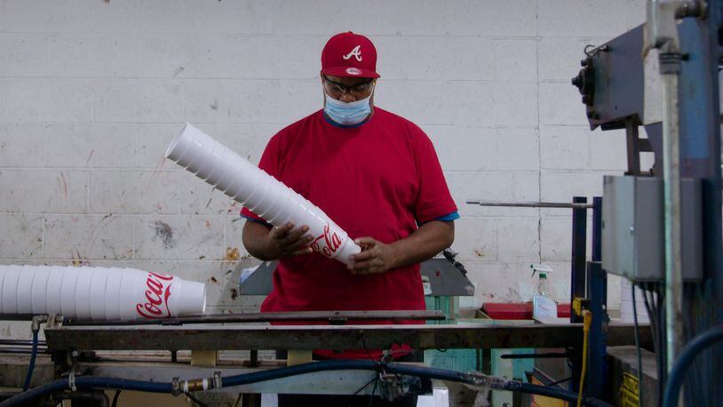 Rufus “Junior” Willis holding a stack of 44 ounce car cups coming off the WinCup assembly line in Stone Mountain. Despite talk of a recession, demand for its products still strong, the company says.