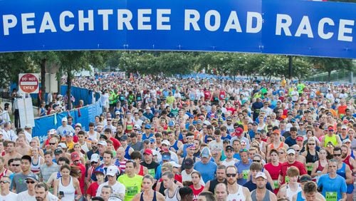 Runners cross the starting line during the 48th AJC Peachtree Road Race, Tuesday, July 4, 2017.