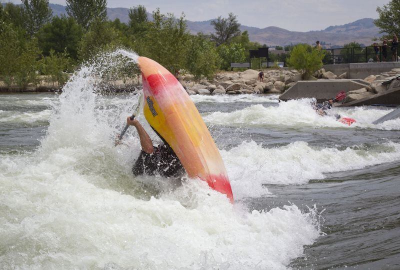 Every day at noon, Boise Parks and Recreation changes the shape of the wave at Boise Whitewater Park to accommodate kayakers and boogie boarders or surfers. Wave technician and kayaker Andrew Webb does a trick called a "loop," that looks like a backward summersault in a boat. (Katherine Jones/Idaho Statesman/TNS)