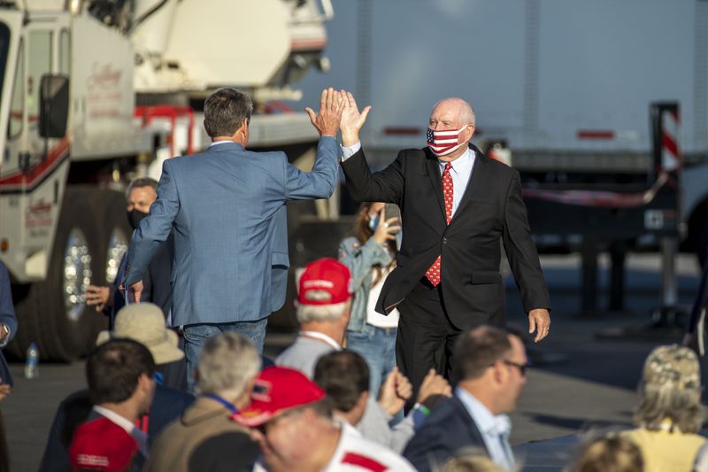 10/16/2020 -Macon, Georgia - U.S. Secretary of Agriculture Sonny Perdue (right) give Gov. Brian Kemp a high five as he prepares to make remarks at a President Donald Trump rally at Middle Georgia Regional Airport in Macon, Friday, October 16, 2020.  (Alyssa Pointer / Alyssa.Pointer@ajc.com)