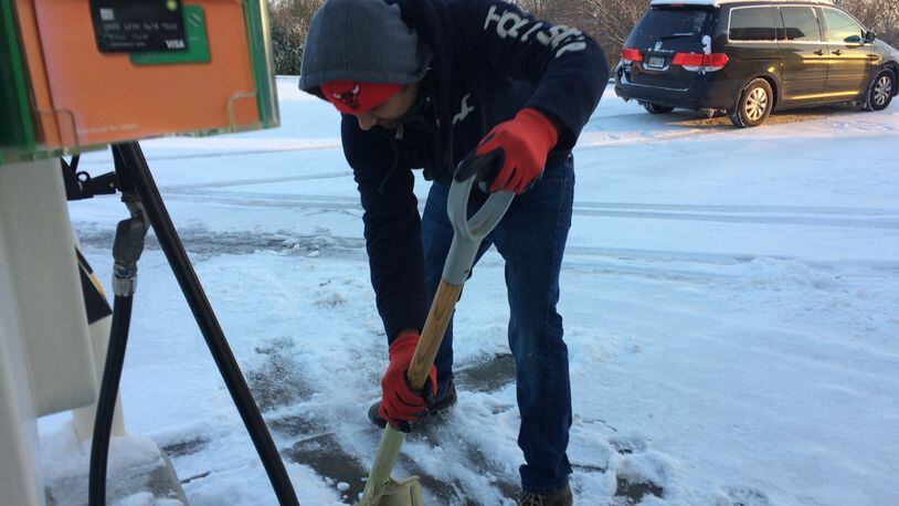 Harry Patel shovels snow at his BP station in Blue Ridge Saturday.