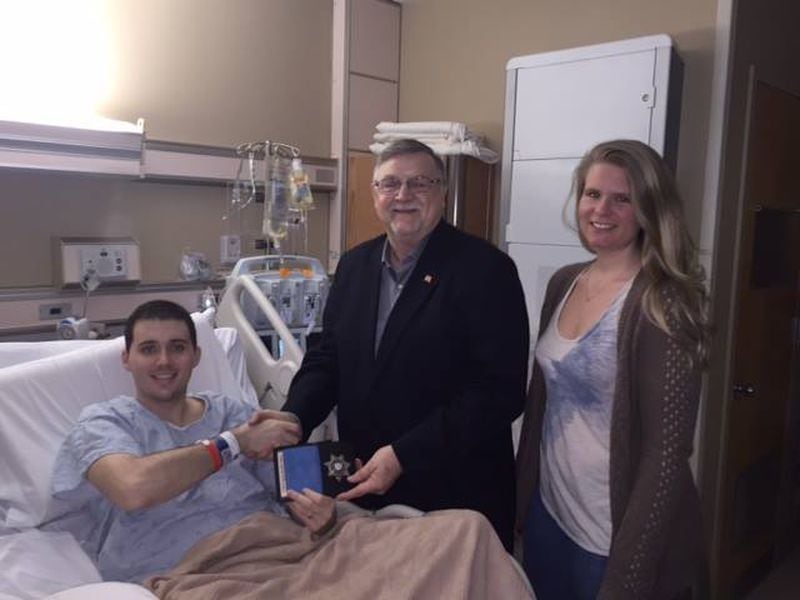 Cobb County Sheriff Neil Warren and Christopher and Jamie Lynn Sparkman recently. Christopher was able to come home recently after enduring around 40 procedures. His road to recovery remains a long one.