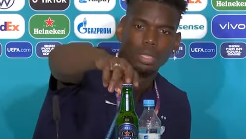 In a move reminiscent to Cristiano Ronaldo’s just a day earlier, France playmaker Paul Pogba moved a bottle of Heineken beer away from sight ahead of a news conference. (Image: YouTube screenshot)