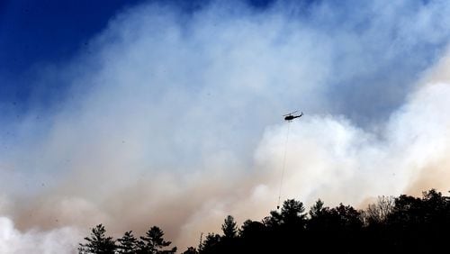 November 16, 2016, Tate City: A wall of smoke fills the air while a helicopter drops water on Pot Gap Ridge battling against the Rock Mountain Fire as it approaches homes on Wednesday, Nov. 16, 2016, in Tate City. Curtis Compton/ccompton@ajc.com