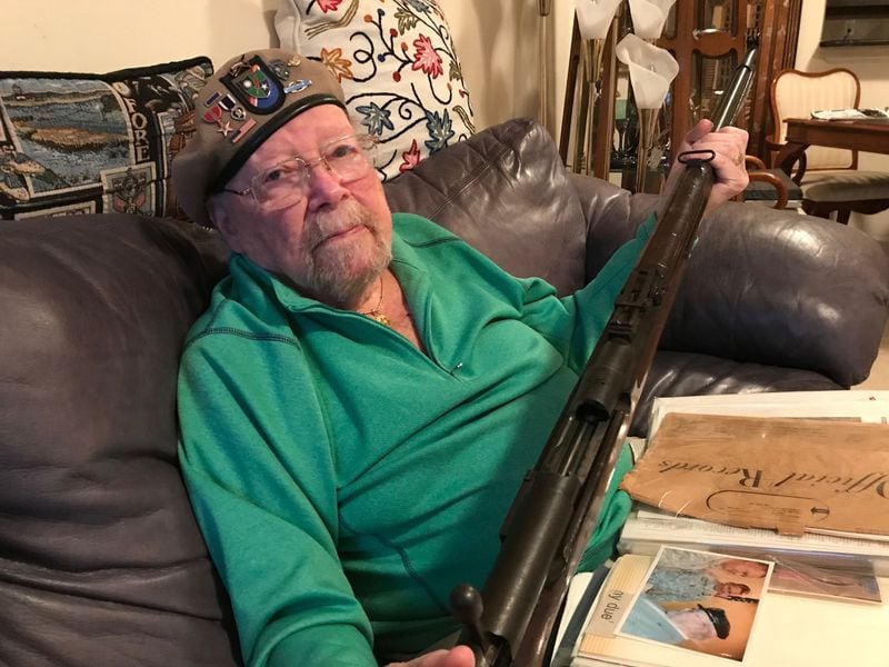 Stanley Sasine holds a rifle recovered from an enemy sniper during World War II. The way Sasine tells the story, he and the sniper exchanged shots. He was wounded; the sniper was killed. BO EMERSON / BEMERSON@AJC.COM