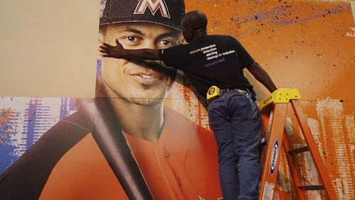 Francois Diesiul hangs a poster bearing the visage of Marlins star Giancarlo Stanton, Thursday, July 7, 2017, at the Miami Beach Convention Center where the Major Leaqgue All Star Game FanFest will open Friday morning
...SOUTH FLORIDA OUT; NO MAGS; NO SALES; NO INTERNET; NO TV...
