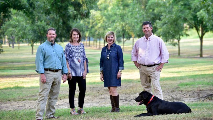 Pecan Ridge Plantation is a family operation headed by (left to right) Rob Cohen and his wife, Rebecca, Mollie Cohen and her husband Eric. Black lab Tate, the company's truffle hunter, is at Eric's feet. (Photo credit: Todd Stone Photography)