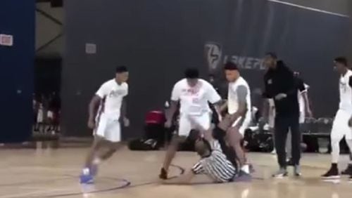 A screenshot from a Twitter video of the brawl  shows a referee surrounded by players.