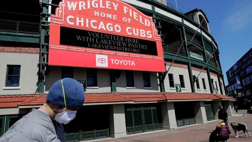 In this April 16, 2020 file photo, Wrigley Field's marquee displays Lakeview Pantry volunteer information in Chicago.