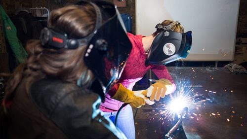 Bria Sativa Aguayo, left, founder of the Atlanta-based Becoming a Welder Inc., teaches a recent local workshop on careers in welding. She is trying to draw more women into the industry.
