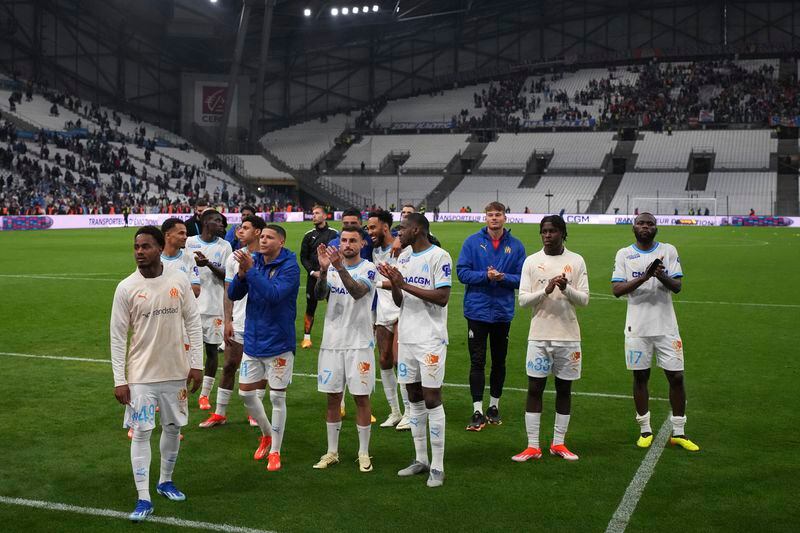 Marseille players celebrate after defeating Lens in a French League One soccer match at the Stade Velodrome stadium in Marseille, France, Sunday, April 28, 2024. Marseille won 2-1. (AP Photo/Daniel Cole)