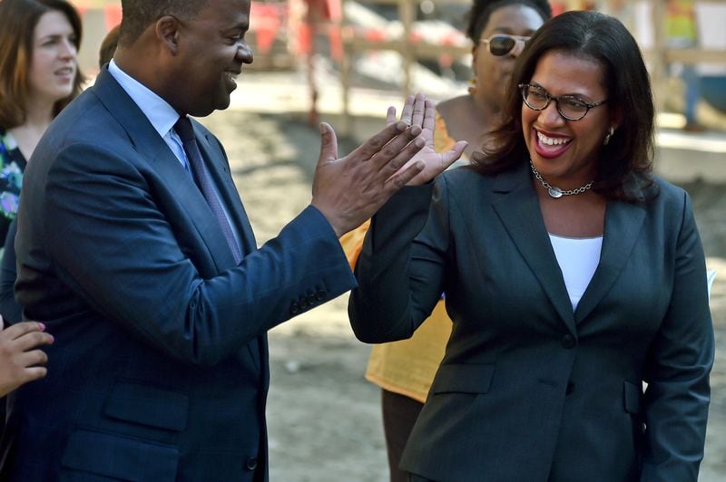 Then-Atlanta Mayor Kasim Reed, left, high-fives with Watershed Commissioner Kishia Powell at an event in 2017. AJC FILE PHOTO.