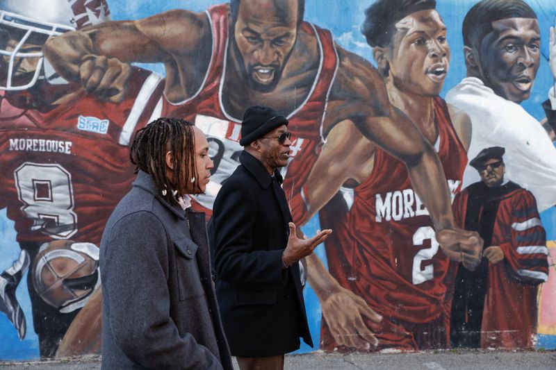 Morehouse student and AJC intern Auzzy Byrdsell, left, chats with Morehouse alumnus Edwin Moses as they walkd in front of a mural featuring Moses. (Natrice Miller/ Natrice.miller@ajc.com)