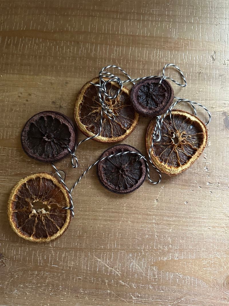 The purple-hued dried oranges in this dried orange garland were repurposed from a batch of mulled wine.
(Julia Skinner for The Atlanta Journal-Constitution)