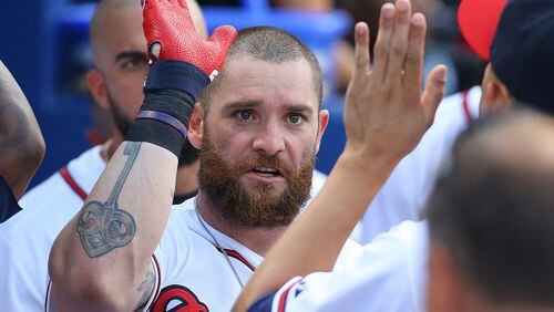 Braves’ Jonny Gomes gets high-fives in the dugout after hitting a two-run home run to take a 2-1 lead over the Rockies at Turner Field on Monday, Aug. 24, 2015, in Atlanta. (Curtis Compton/ccompton@ajc.com)