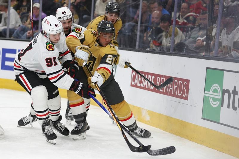 Chicago Blackhawks center Frank Nazar (91) attempts to steal the puck from Vegas Golden Knights defenseman Alec Martinez (23) during the third period of an NHL hockey game Tuesday, April 16, 2024, in Las Vegas. (AP Photo/Ian Maule)