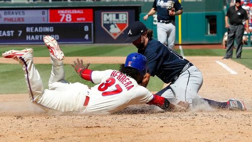 Odubel Herrera of the Phillies is tagged out at home by Braves pitcher R.A. Dickey after a wild pitch during the sixth inning of a baseball game against the Atlanta Braves, Sunday, July 30, 2017, in Philadelphia.