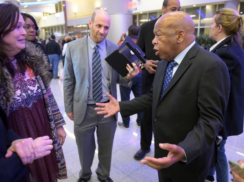 Congressman John Lewis (D-Ga, right) speaks with attorneys Sarah Owings and Daniel Werner outside the Customs and Border Protection office at Hartsfield International airport Saturday.