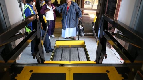 Sarah Colquitt points to one of the Transdev bus drivers to make sure she will watch her in case she slips on the way up the lift to the bus at the Southeast Neighborhood Senior Center in Atlanta. (HENRY TAYLOR / HENRY.TAYLOR@AJC.COM) AJC FILE PHOTO