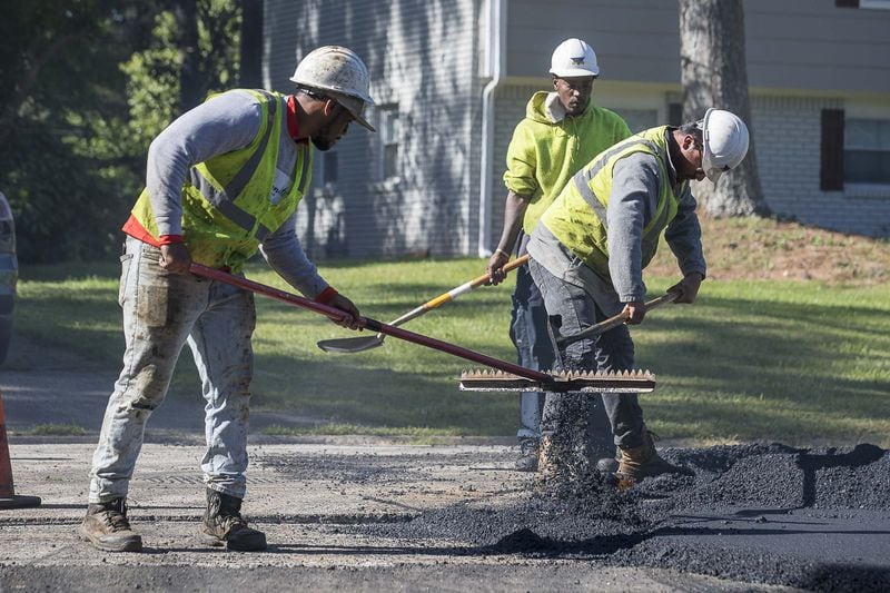An H.E.H. Paving crew works to lay asphalt on Gwendon Terrace in Decatur, Thursday, April 16, 2020. The paving project is part of the DeKalb County Special Purpose Local Option Sales Tax. (ALYSSA POINTER / ALYSSA.POINTER@AJC.COM)