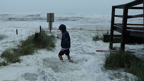 Cameron Sadowski walks along where waves are crashing onto the beach as the outer bands of  hurricane Michael arrive on October 10, 2018 in Panama City Beach, Florida. The hurricane is forecast to hit the Florida Panhandle as a possible category 4 storm.