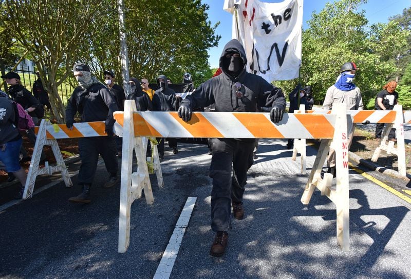 Counter-protesters march outside Stone Mountain Park on Saturday, April 23, 2016. Violent protests surrounding a white power rally at Stone Mountain caused officials to shut down public attractions at the park. HYOSUB SHIN / HSHIN@AJC.COM