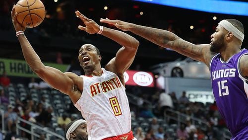 Hawks’ Dwight Howard is fouled on his way to the basket on a double team by Kings’ Ty Lawson and DeMarcus Cousins during the second period in an NBA basketball game on Monday, Oct. 31, 2016, in Atlanta. Curtis Compton /ccompton@ajc.com